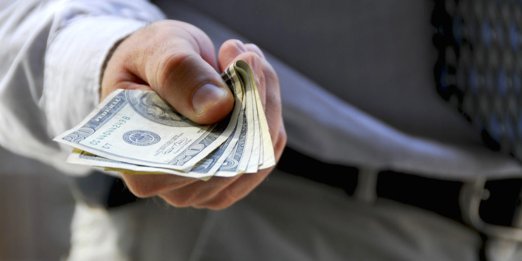 Hand of a businessman offering money