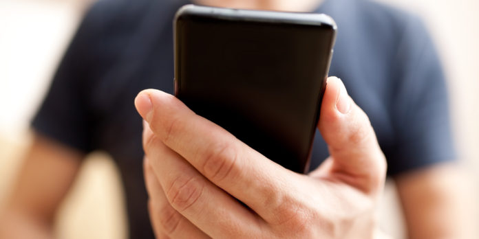 Close up of a man using mobile smart phone
