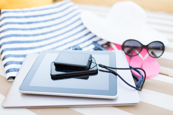 close up of tablet pc and smartphone on beach